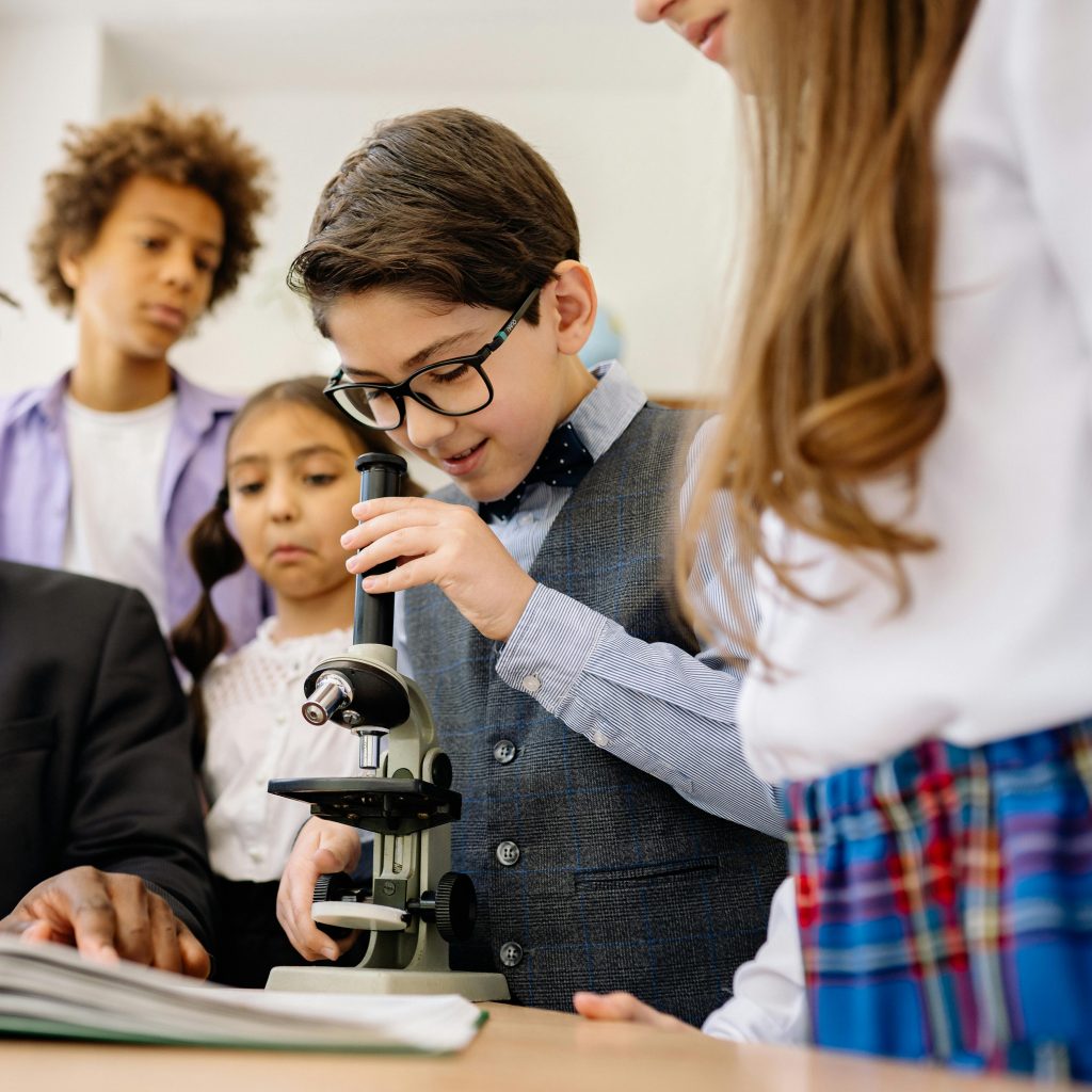A Boy Looking Down a Microscope